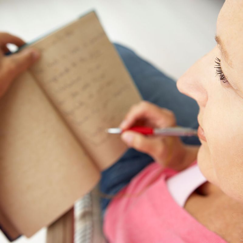 Senior woman writing in notebook