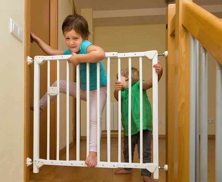 Little sisters near stair gate